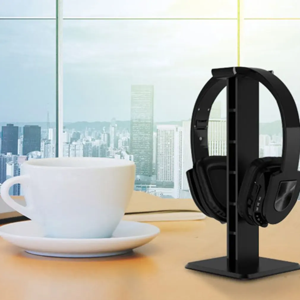 Un soporte de auriculares negros con una taza de café en una mesa