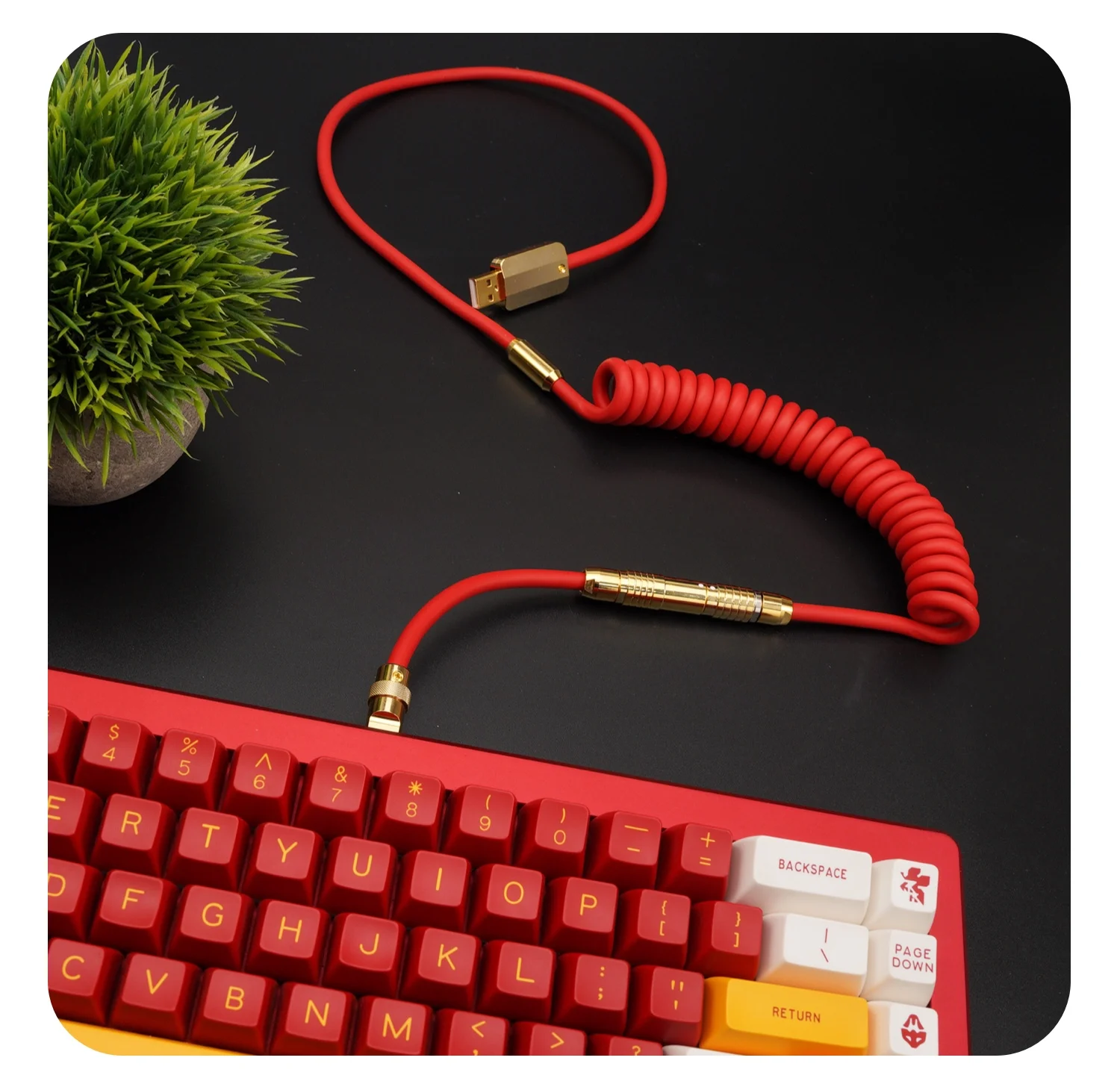 Un teclado rojo con cable y planta verde