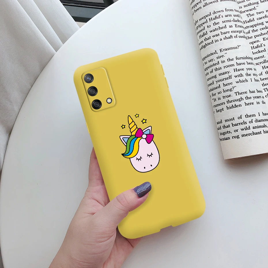Una persona que sostiene un teléfono celular amarillo con un unicornio