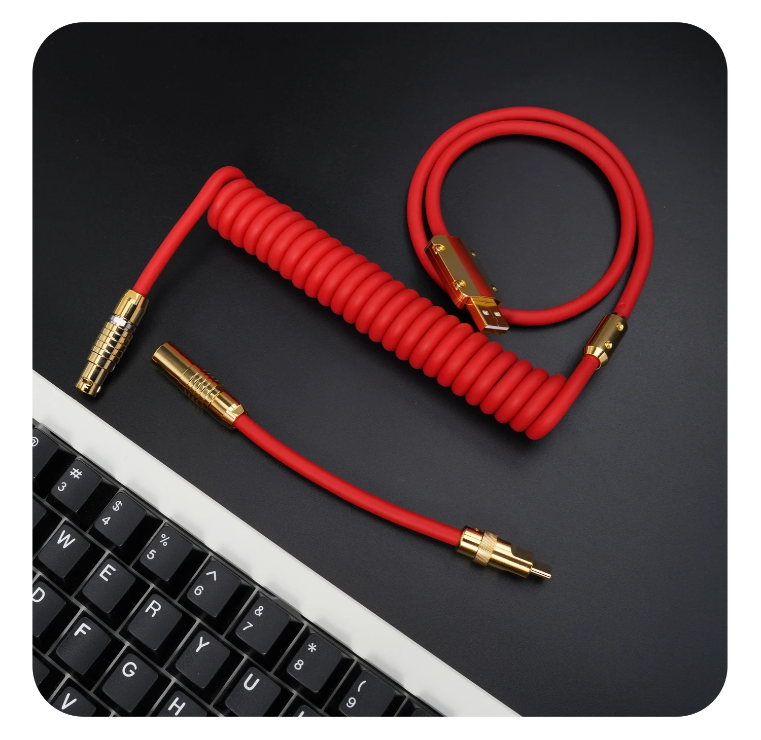 Un cable rojo se coloca en una mesa negra al lado de un teclado