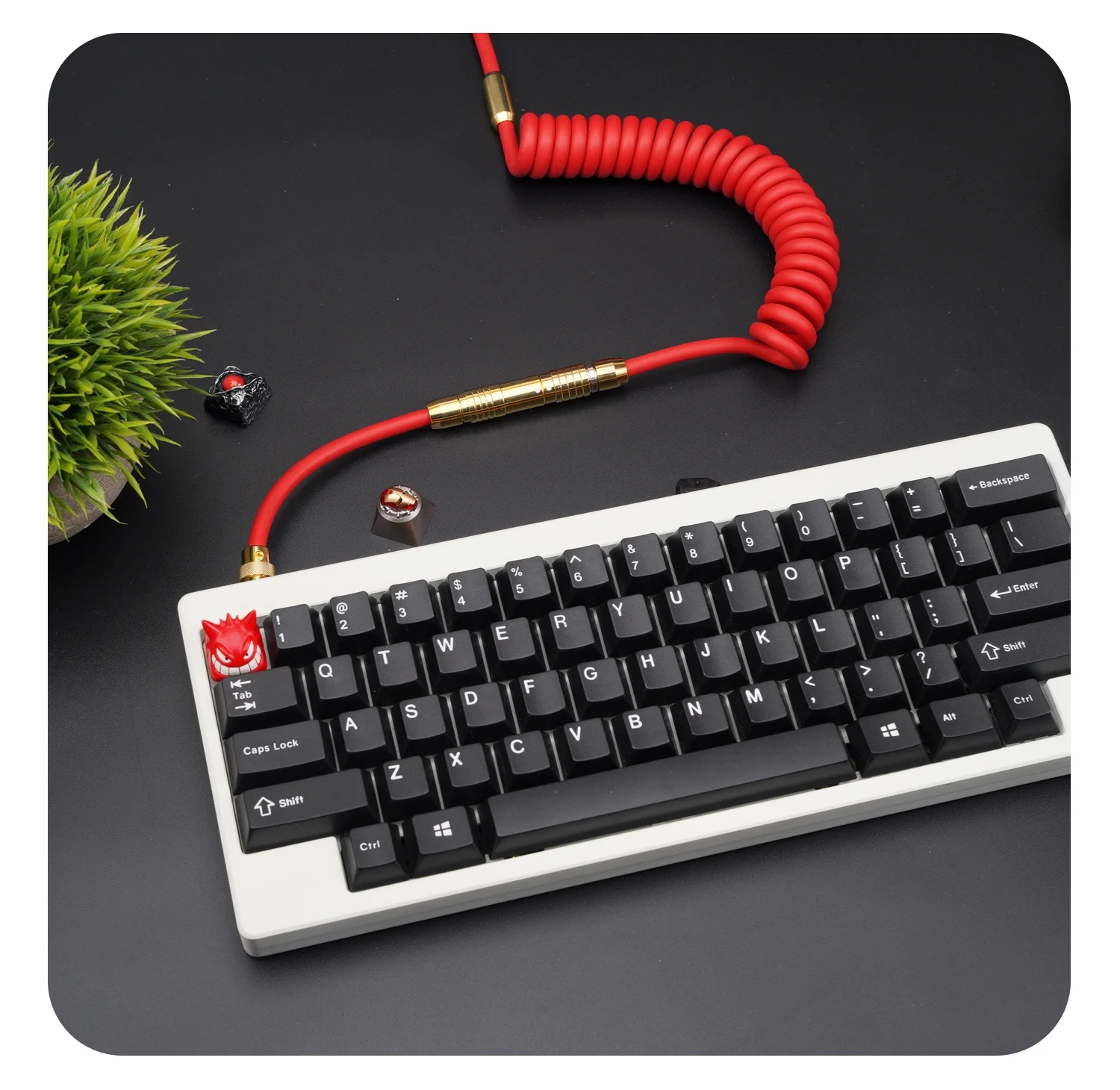 Un teclado blanco con un cordón rojo y una tecla roja y negra
