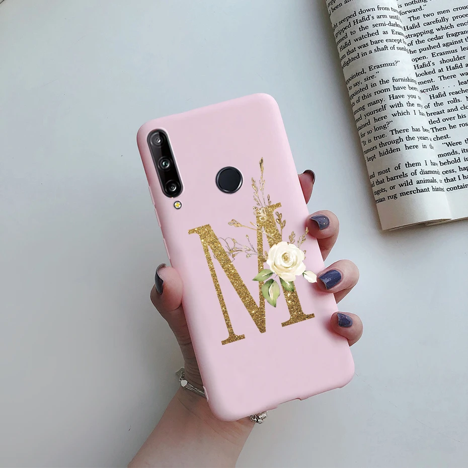 Un teléfono celular rosa con un oro M