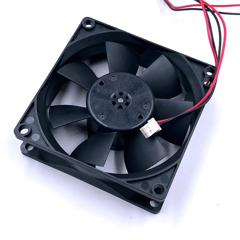 Un ventilador negro con un alambre rojo unido