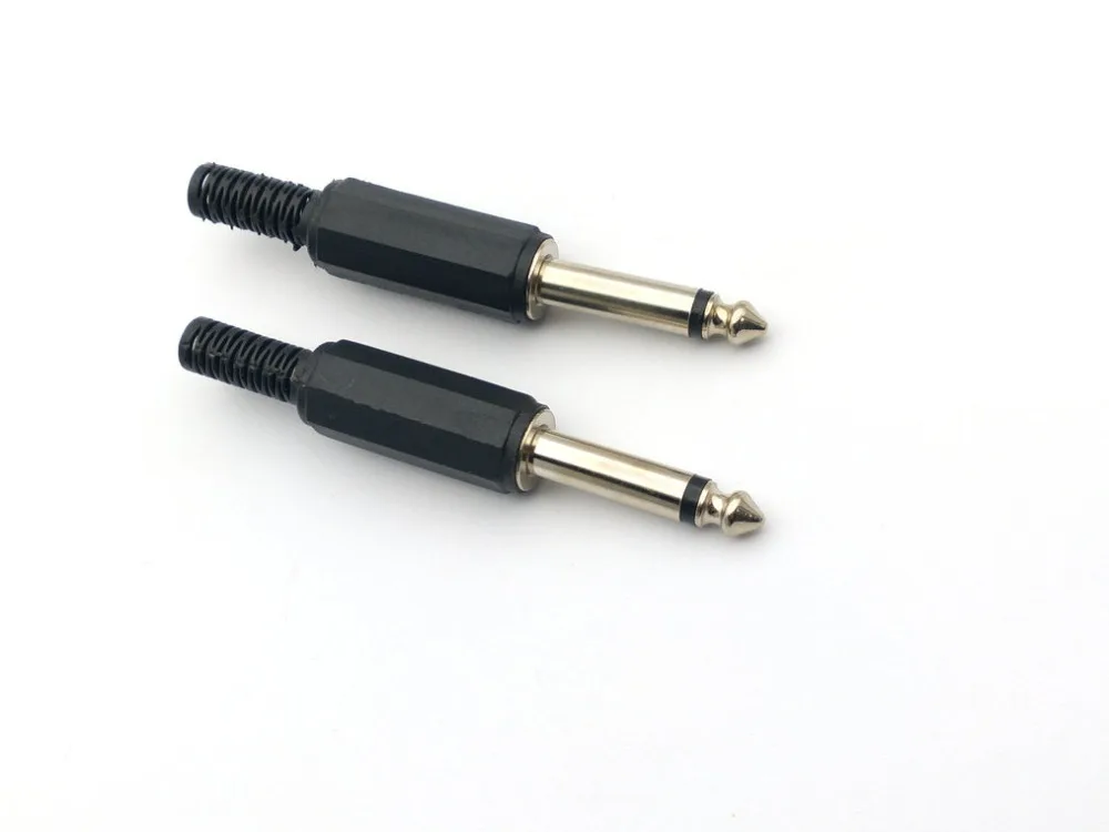 Dos enchufes negros y dorados sobre un fondo blanco