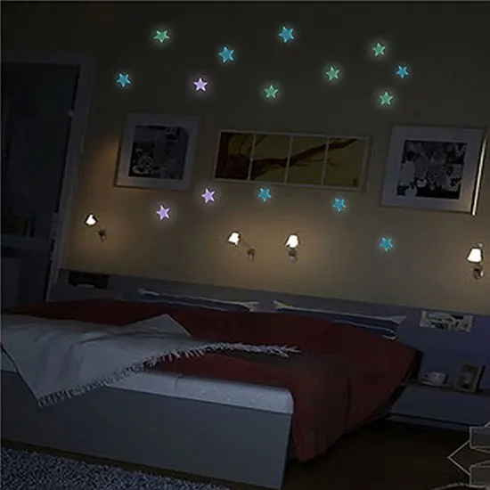 Un dormitorio con una cama y una pared con estrellas