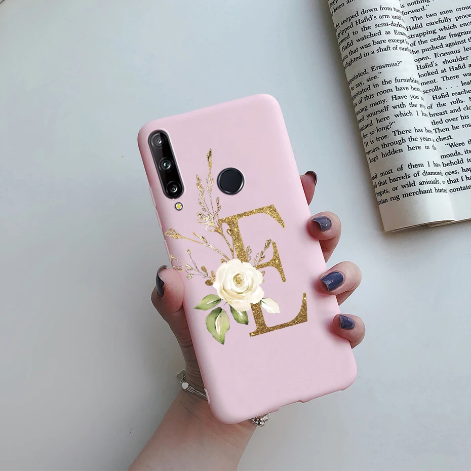 Un teléfono celular rosa con un dorado E
