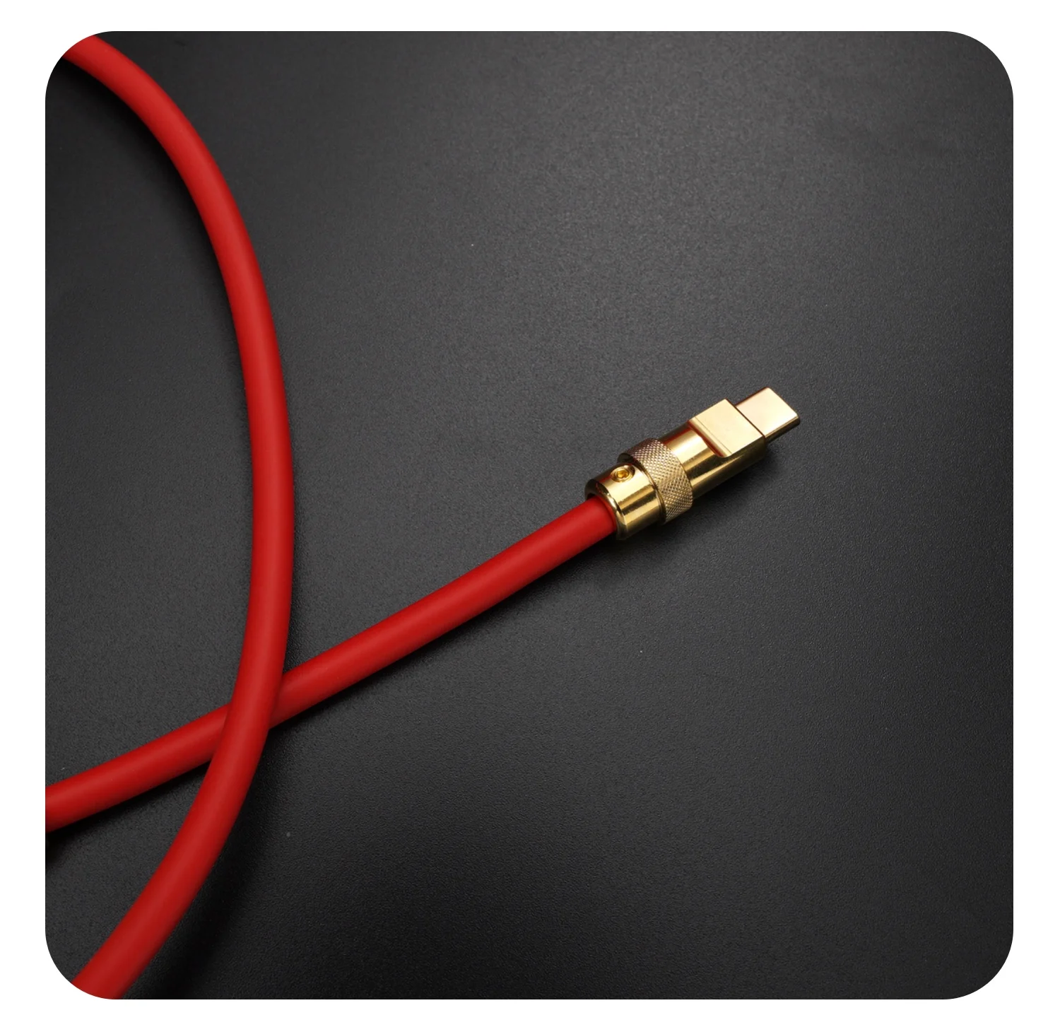 Un cordón rojo con un conector de oro sobre un fondo negro