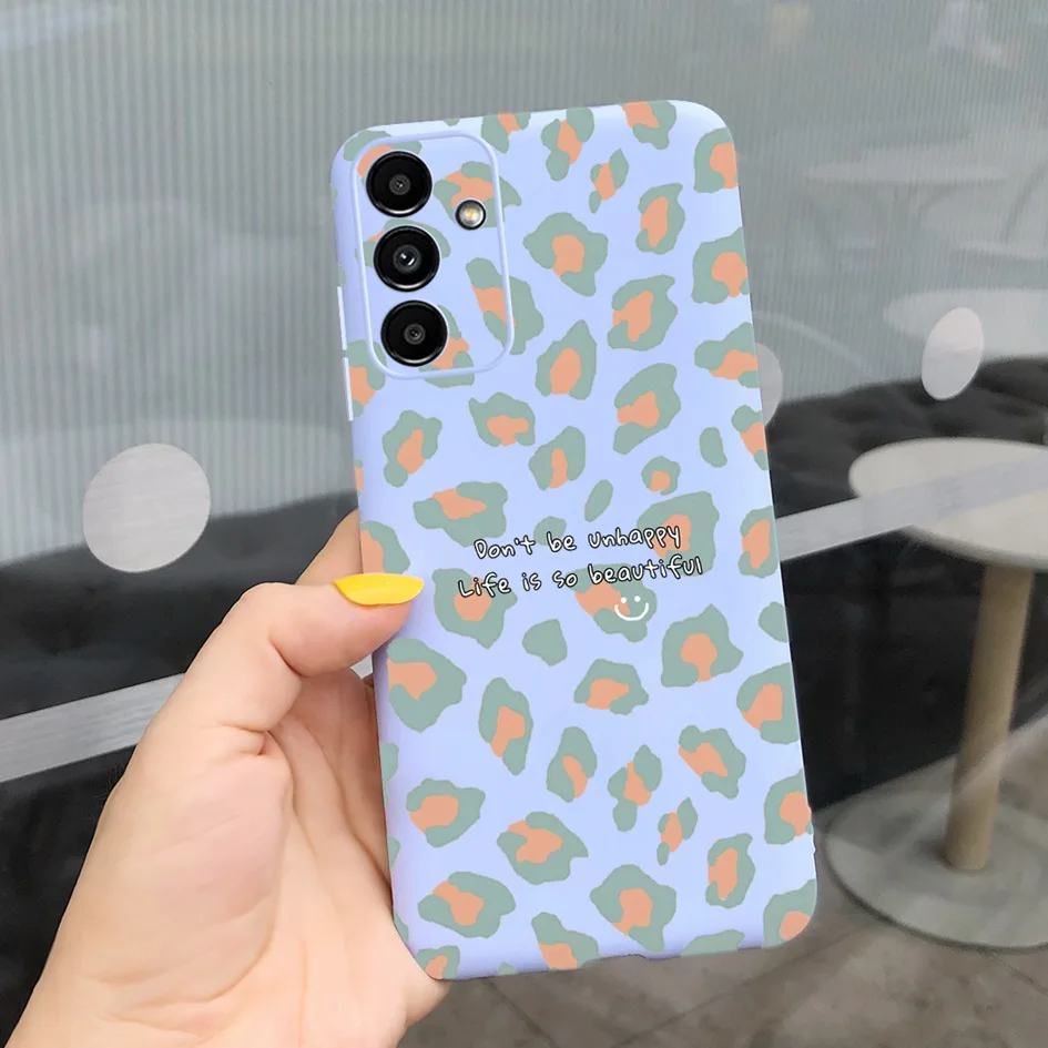 Una persona que sostiene un teléfono celular con una caja de impresión de leopardo azul y verde