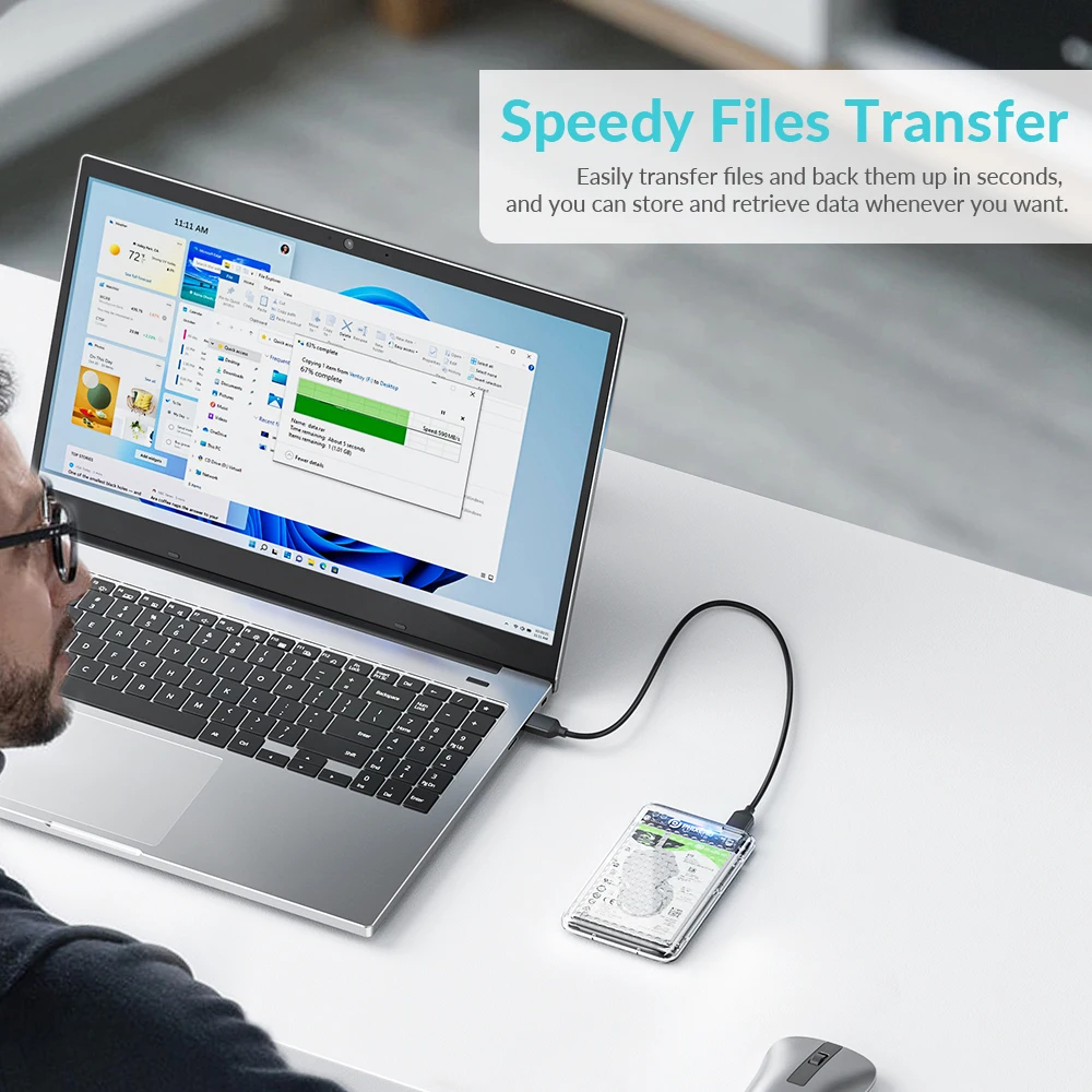Una persona sentada en un escritorio con una computadora portátil. La pantalla de la computadora portátil muestra una ventana de transferencia de archivos, lo que sugiere que la persona está en el proceso de transferir archivos. Hay una unidad flash USB conectada a la computadora portátil, que probablemente se esté utilizando para la transferencia de archivos.