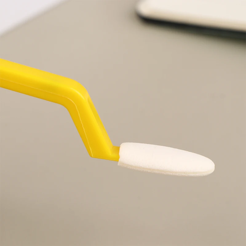 Un cepillo de dientes amarillo con una cerda blanca