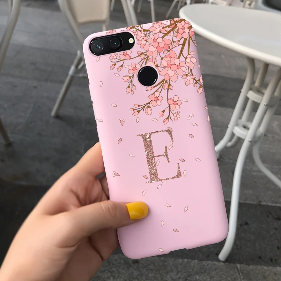 Una caja de teléfono rosa con un diseño de árbol y la letra E