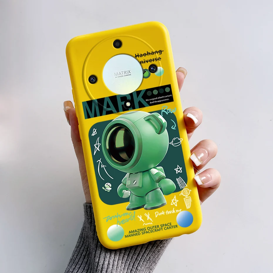 Una persona que sostiene un teléfono celular amarillo con un robot verde