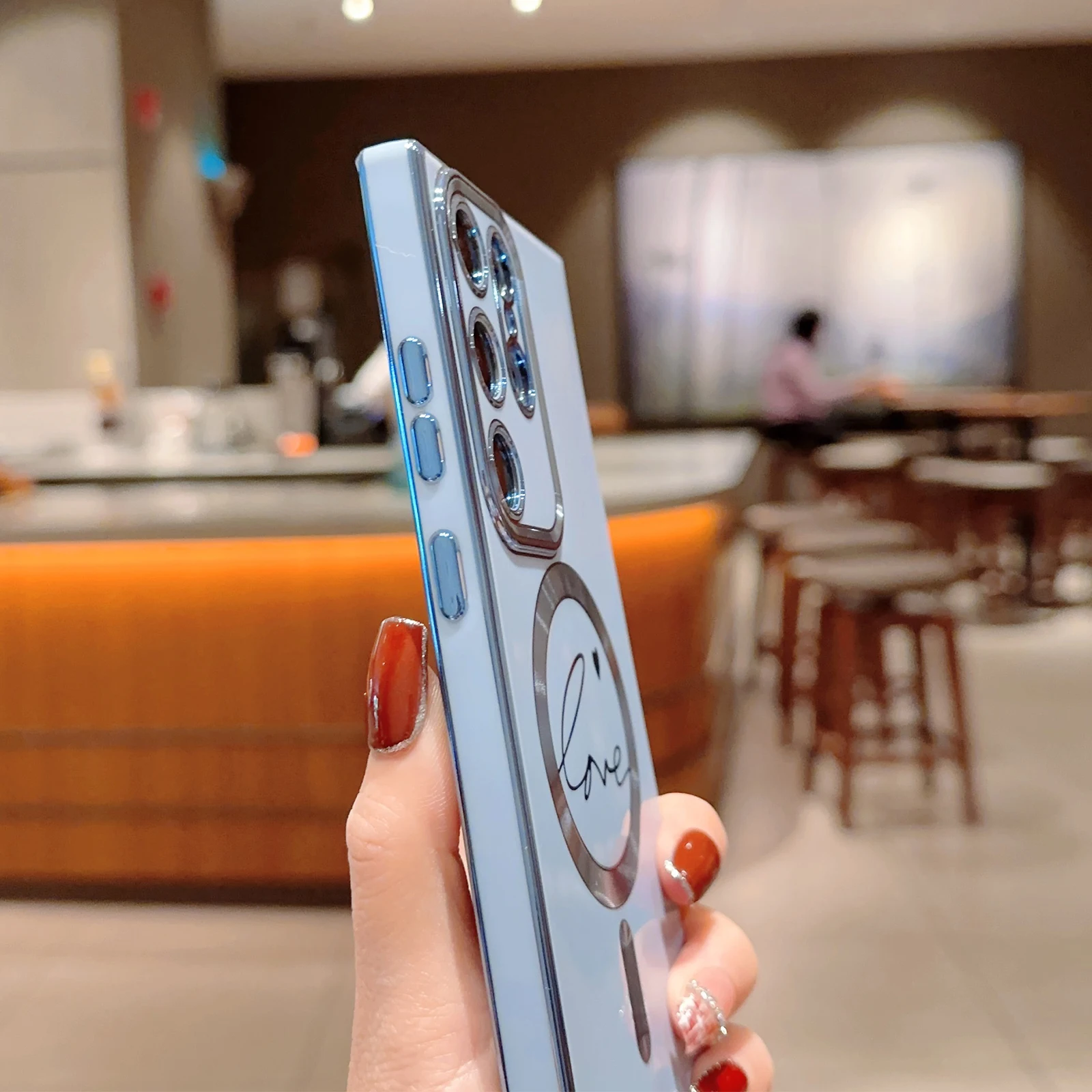 Una persona que sostiene un teléfono celular en el bar