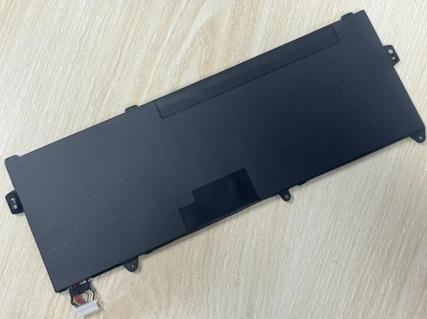 Un dispositivo electrónico negro se encuentra en una mesa de madera