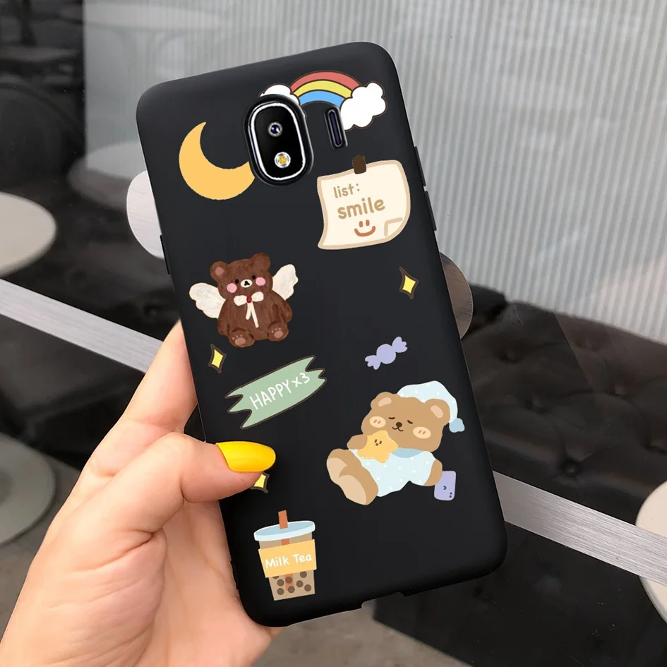 Una persona que sostiene un teléfono celular con un estuche que tiene un oso de peluche y una luna en él