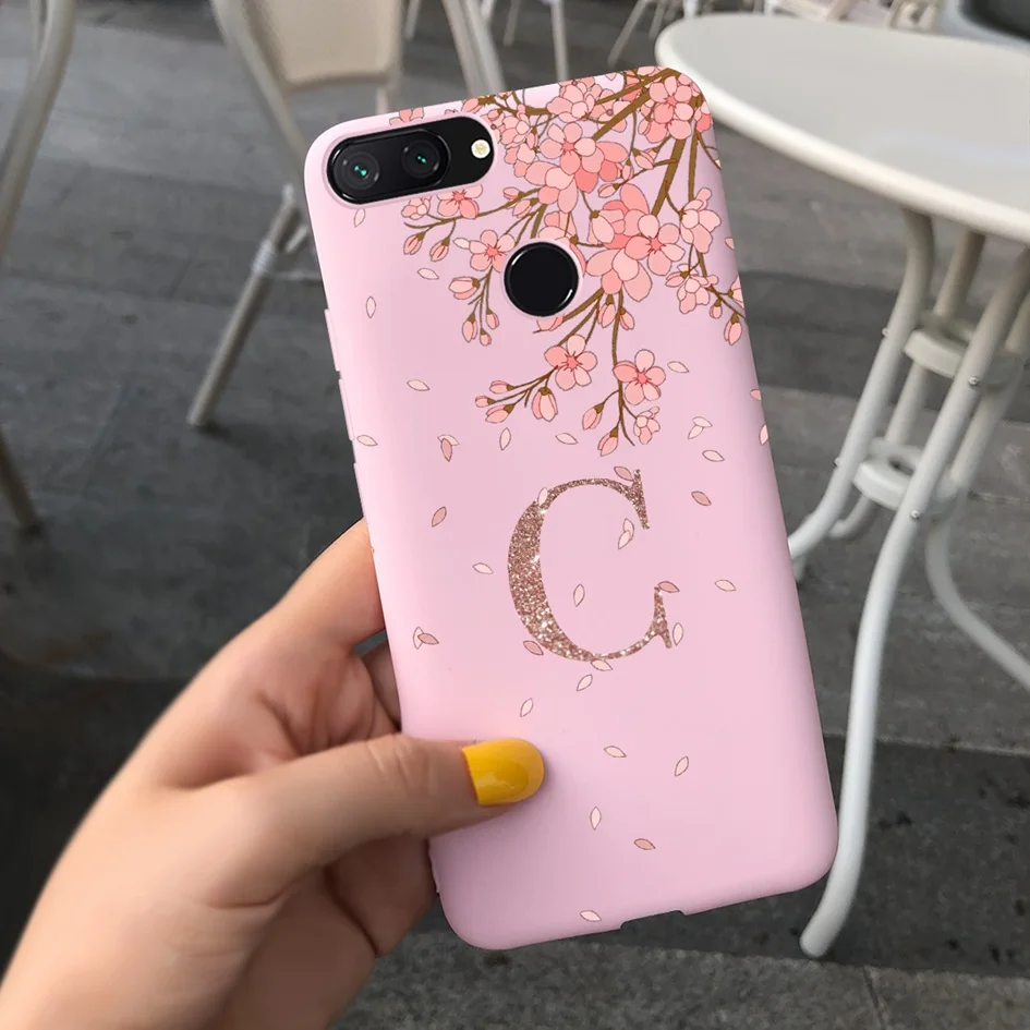 Una caja de teléfono rosa con un diseño de árbol de cerezo en flor y la letra C en él