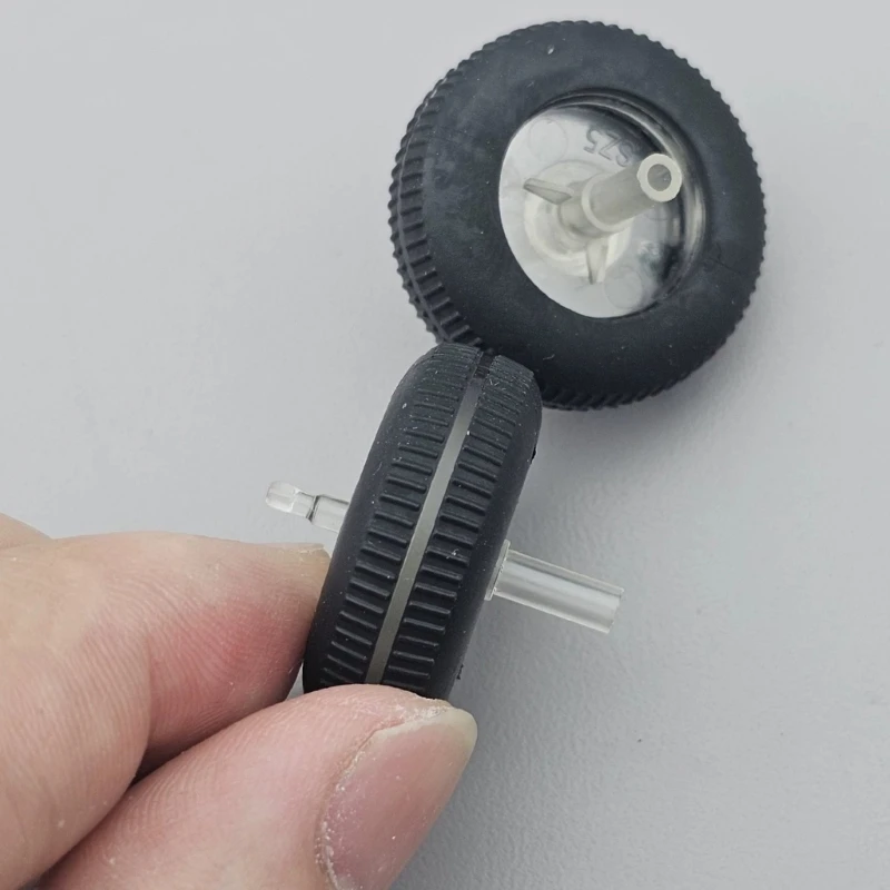 Una persona sostiene una pequeña rueda negra con un centro blanco.