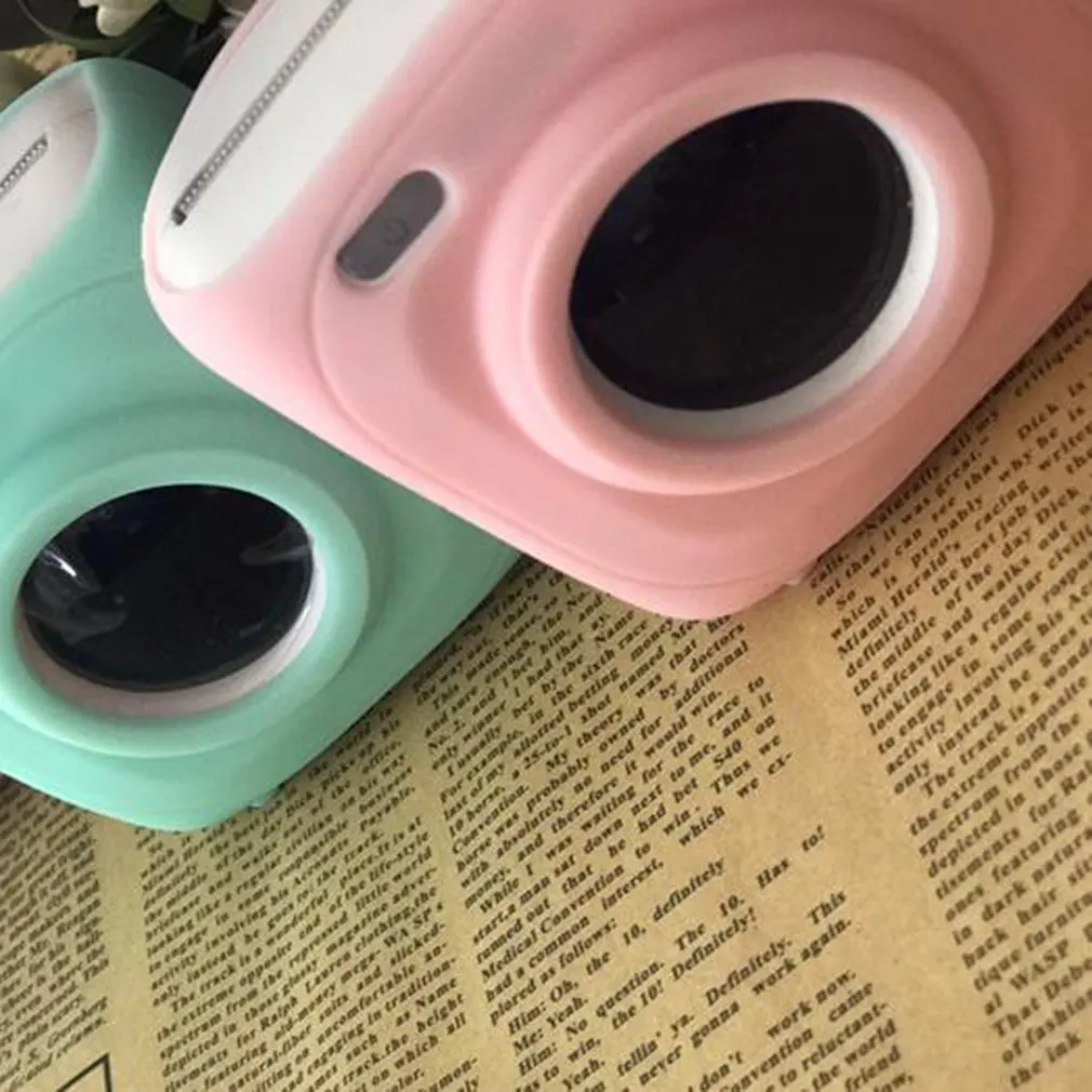 Tres cámaras de colores diferentes están sentados encima de un periódico.