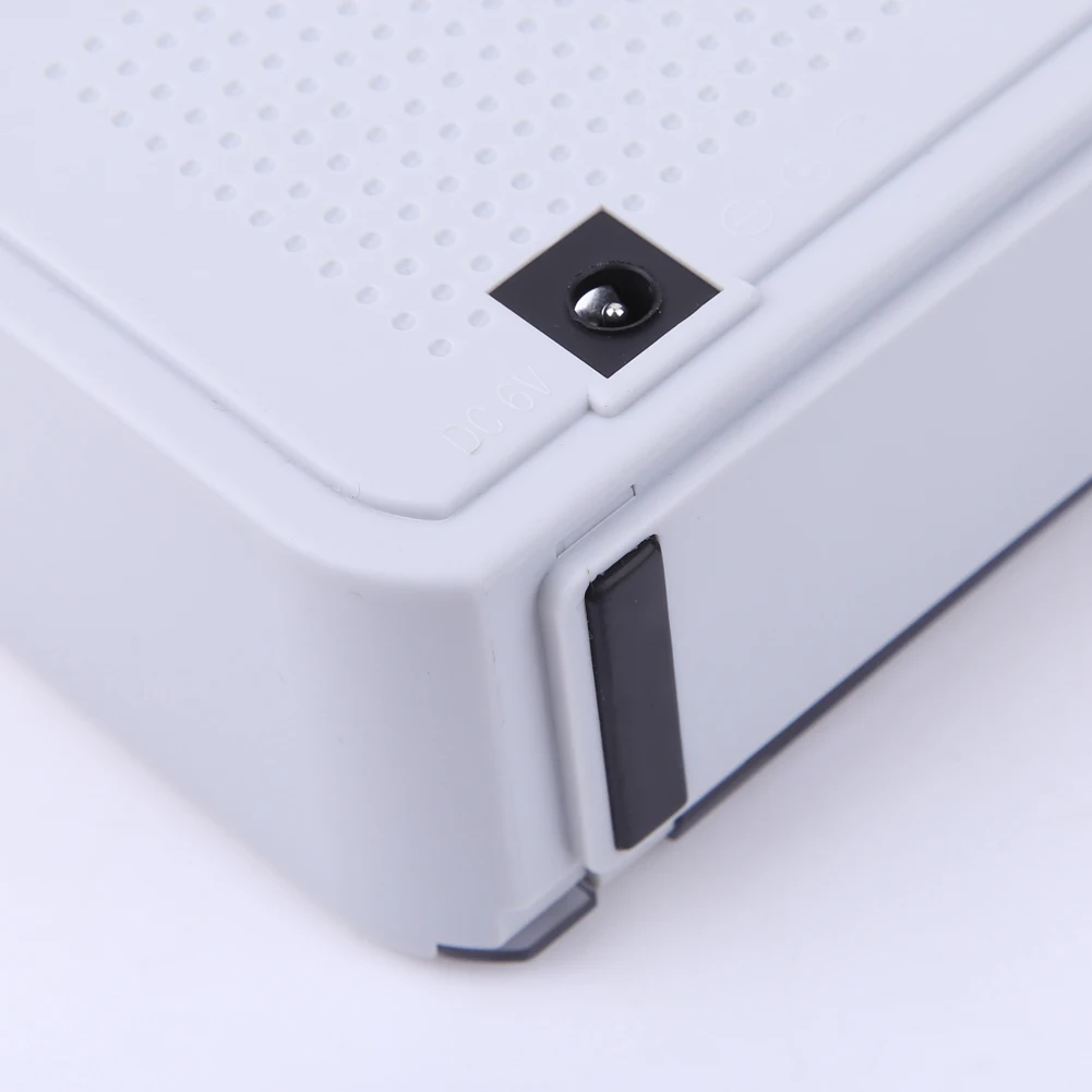 Una caja blanca con un botón negro en el costado