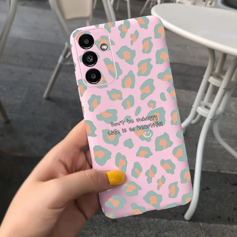 Una persona que sostiene un teléfono celular rosa con una caja de impresión de leopardo