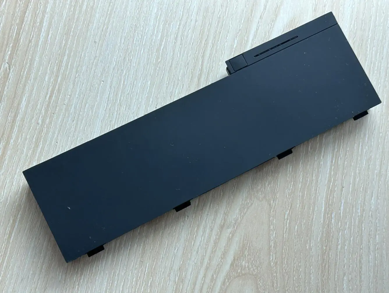 Un objeto negro se encuentra en una mesa de madera