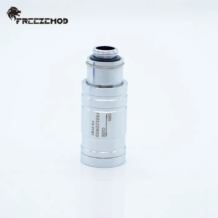 Un objeto plateado con una parte superior negra está sobre un fondo blanco.