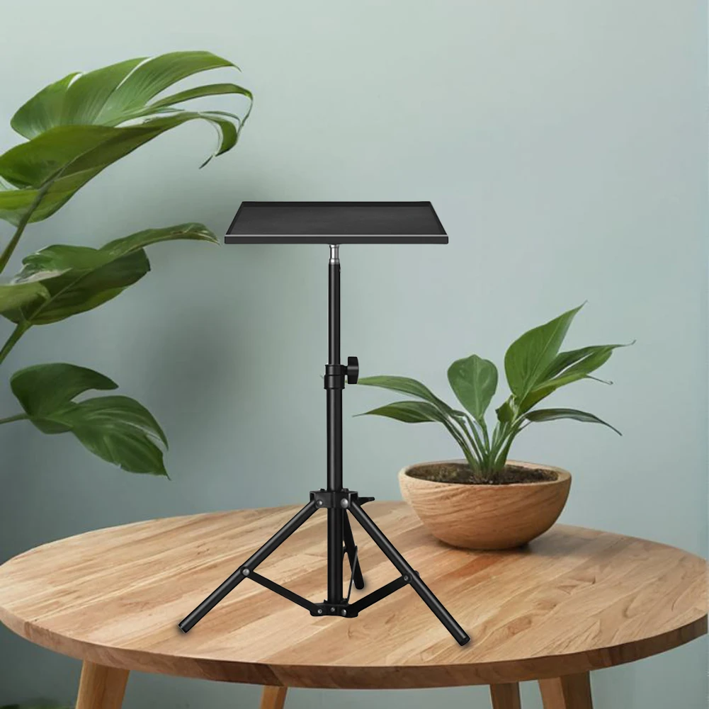 Un soporte de tableta negro sobre una mesa de madera con una planta en un tazón