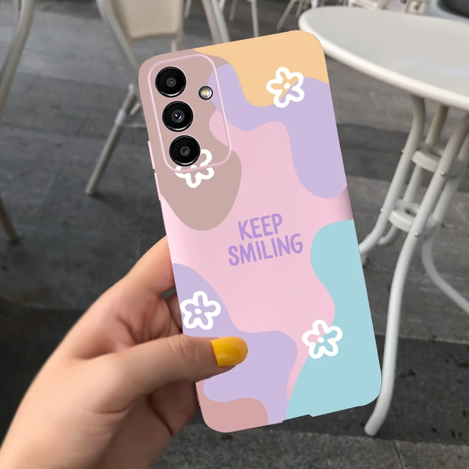 Una persona que sostiene un teléfono celular rosa y blanco con un diseño de flores