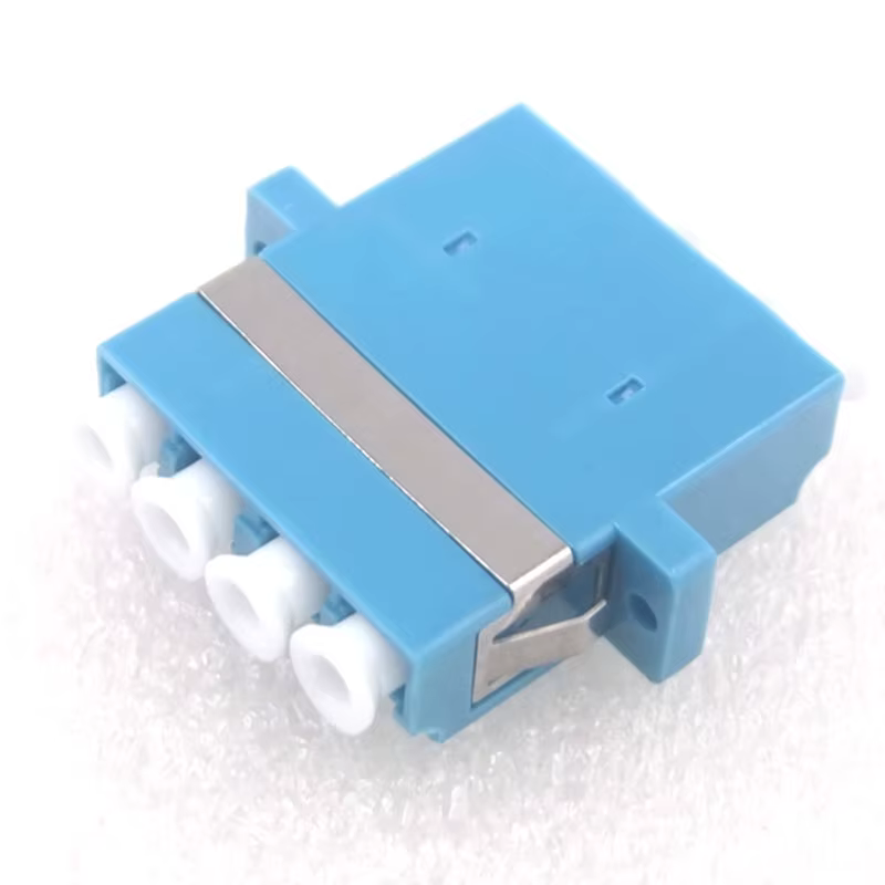 Adaptador LC duplex frontal mostrando el cuerpo metálico y la cerámica interna
